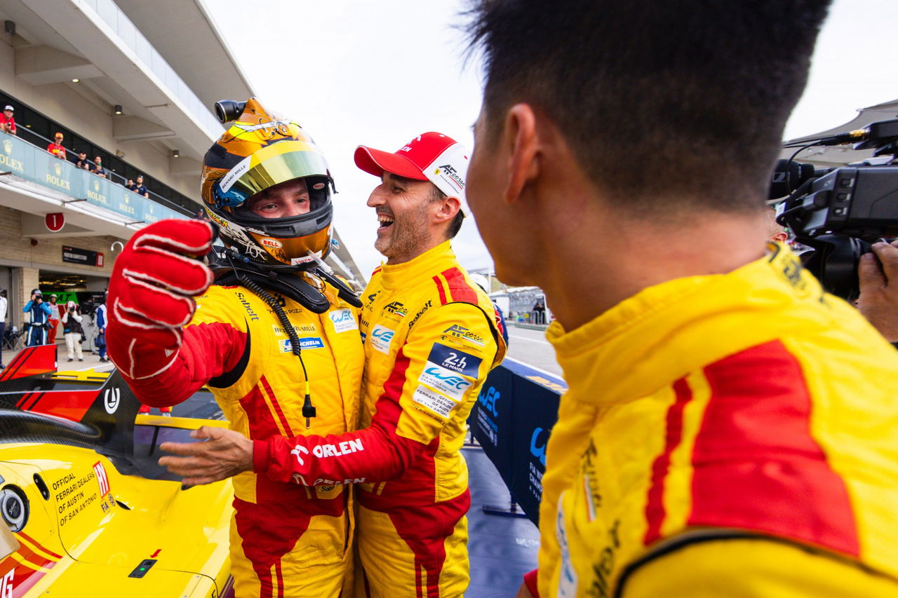 Pilotos del equipo PREMA celebrando en el pit lane. No se aprecia el coche completo.