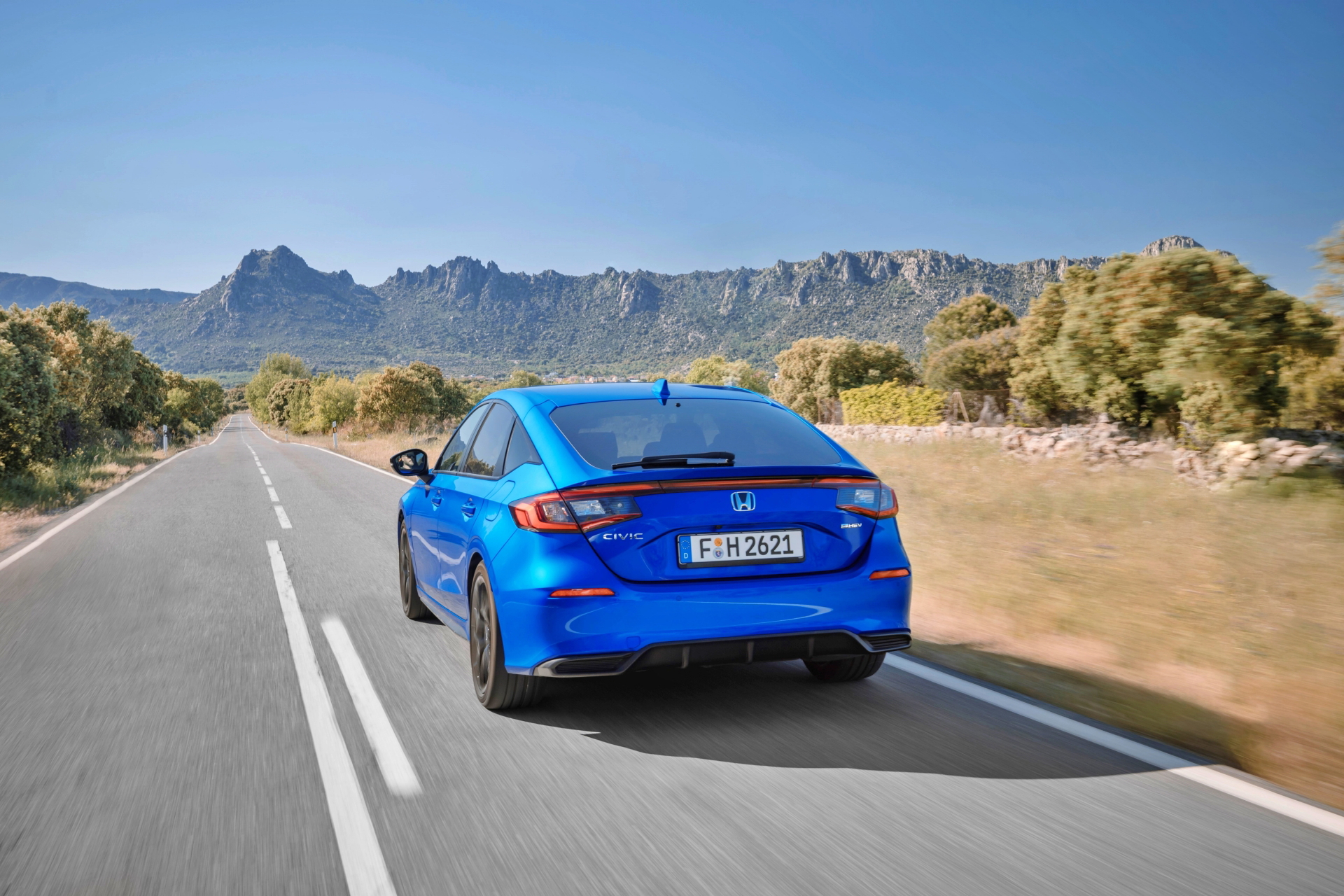 Vista lateral y trasera del Honda Civic 2024 en un entorno natural.
