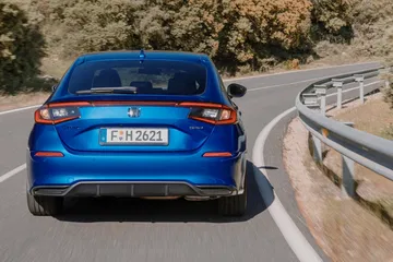 Vista lateral y trasera del Honda Civic 2024, mostrando líneas modernas y aerodinámicas.