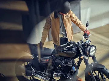 Muestra la Honda GB350S desde un ángulo lateral, destacando su estilo neoclásico.