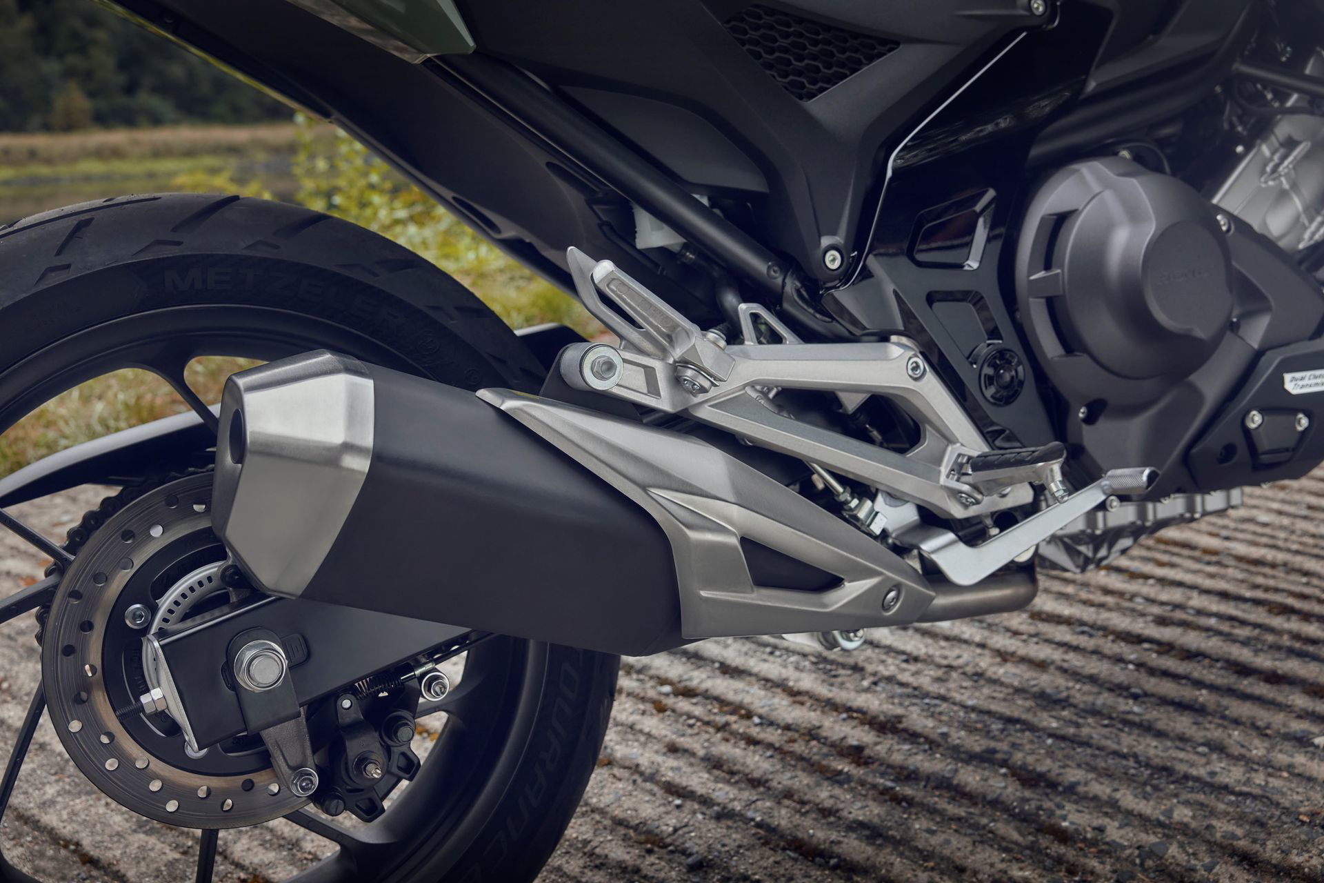 Detalle de la zona del motor y escape de la Honda NC750X, mostrando su diseño eficiente.