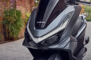 Vista dinámica del Honda PCX 125, destacando su diseño moderno y aerodinámico.