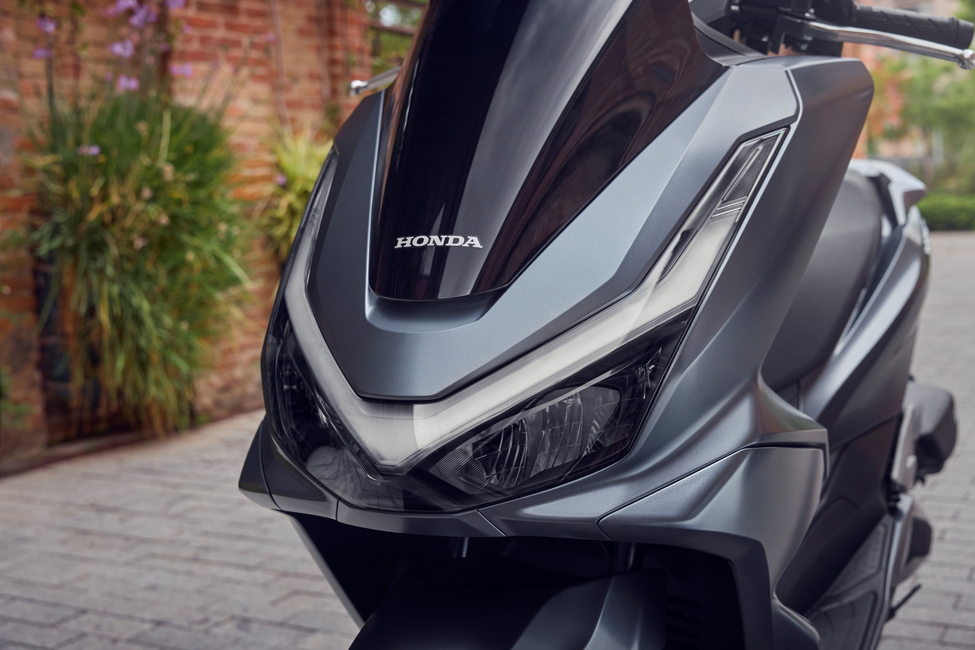 Vista dinámica del Honda PCX 125, destacando su diseño moderno y aerodinámico.