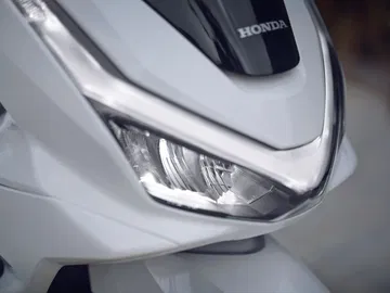 Vista cercana del faro del renovado Honda PCX 125, mostrando su diseño elegante.