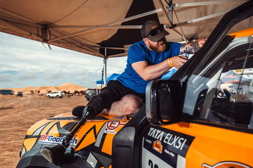 Mecánico trabajando en un vehículo de competición en el Rally Dakar.