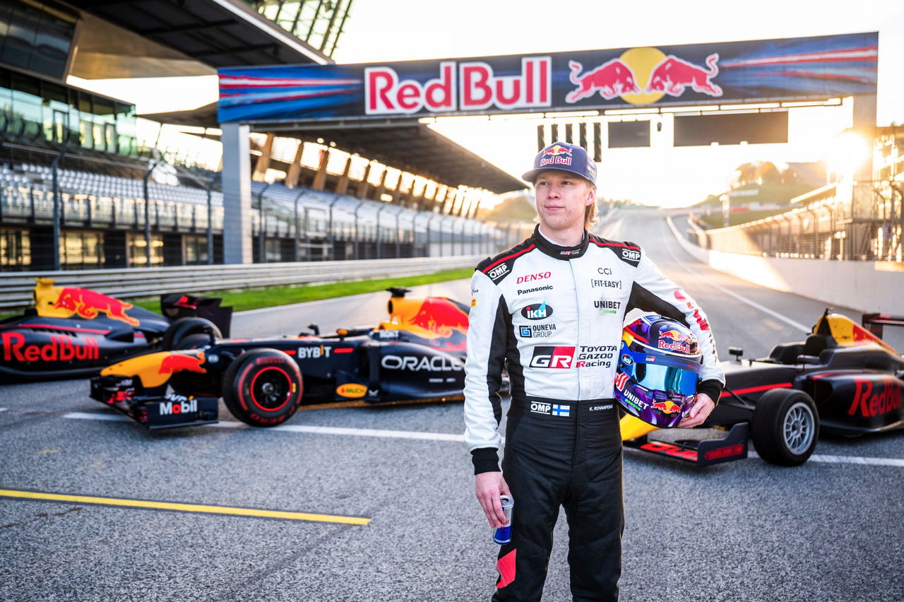 Kalle Rovanperä junto al monoplaza Red Bull RB8, reflejando ambición y velocidad.