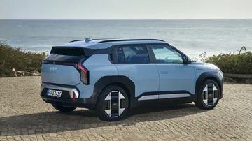 Vista lateral y trasera del Kia EV3, mostrando su diseño moderno y aerodinámico.