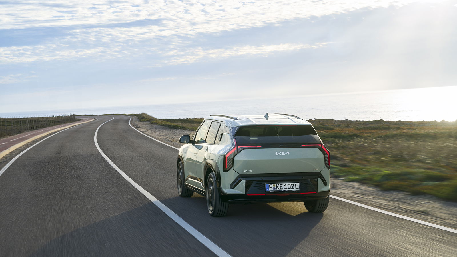 Vista trasera y lateral del Kia EV3 GT-Line en un entorno natural Vista trasera y lateral del Kia EV3 GT-Line en un entorno natural
