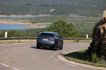 Vista trasera y lateral del MG HS en una carretera pintoresca.