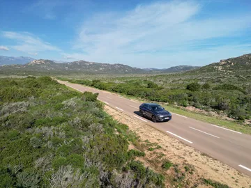 El MG HS se desplaza con elegancia por un paisaje natural, destacando su diseño moderno.