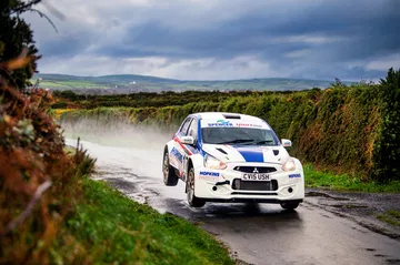 El Mitsubishi Mirage R5 demuestra su destreza en condiciones de rally, dominando el terreno húmedo.