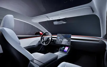 Interior minimalista y moderno del Model 3, resaltando sus tecnologías de conducción.