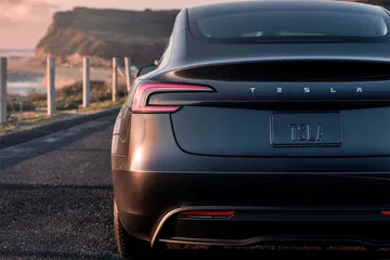 Vista lateral y trasera del Tesla Model 3, que muestra su diseño elegante.