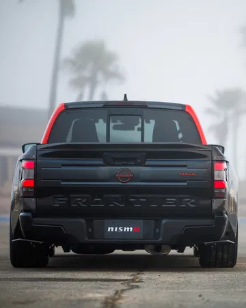 Vista trasera del Nissan Frontier destacando su robustez y diseño en asfalto