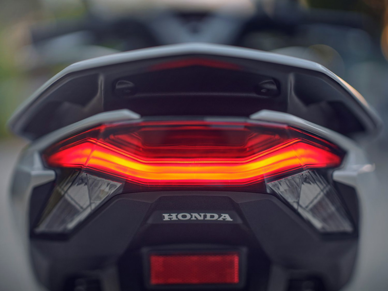 Vista trasera de la Honda PCX 2025 con nuevo disco de freno posterior y detalles actualizados.