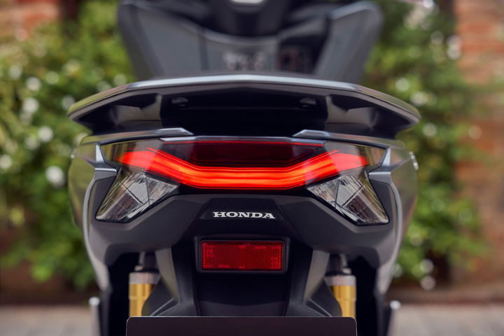 Vista trasera de la Honda PCX 2025 mostrando el nuevo disco de freno trasero y mejoras estéticas.