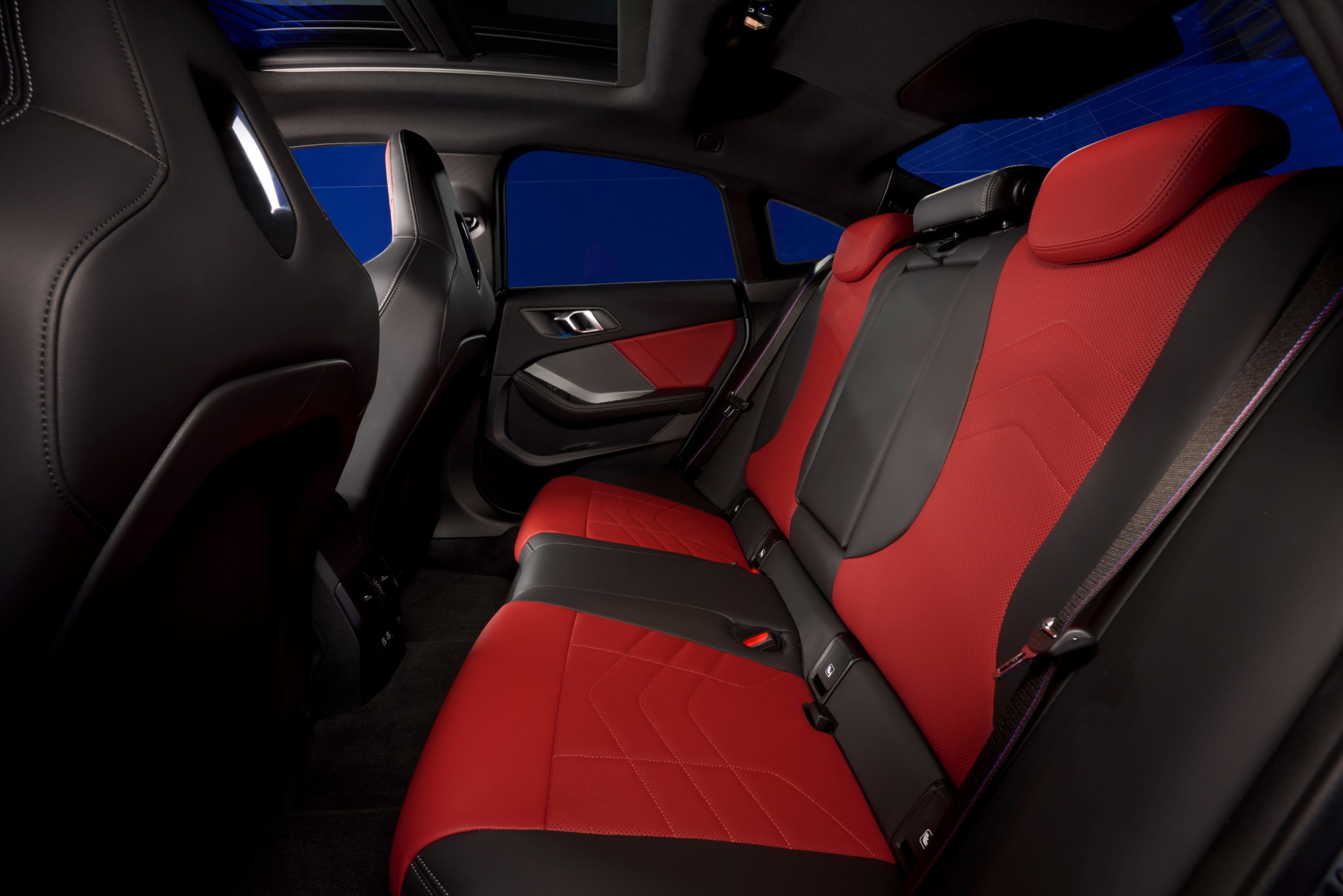 Habitáculo trasero con tapicería roja, reflejo de la deportiva esencia BMW.