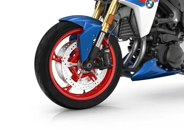 Primer plano de la rueda del BMW F 900 R, destacando su diseño dinámico y colores vibrantes.