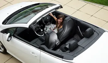 Vista lateral del Peugeot 308 CC con capota abierta, ideal para disfrutar del aire libre.