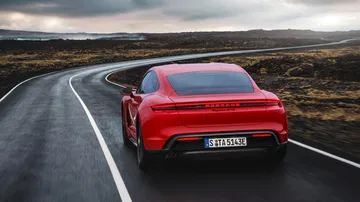 Vista trasera y lateral del Porsche Taycan GTS en un entorno natural.