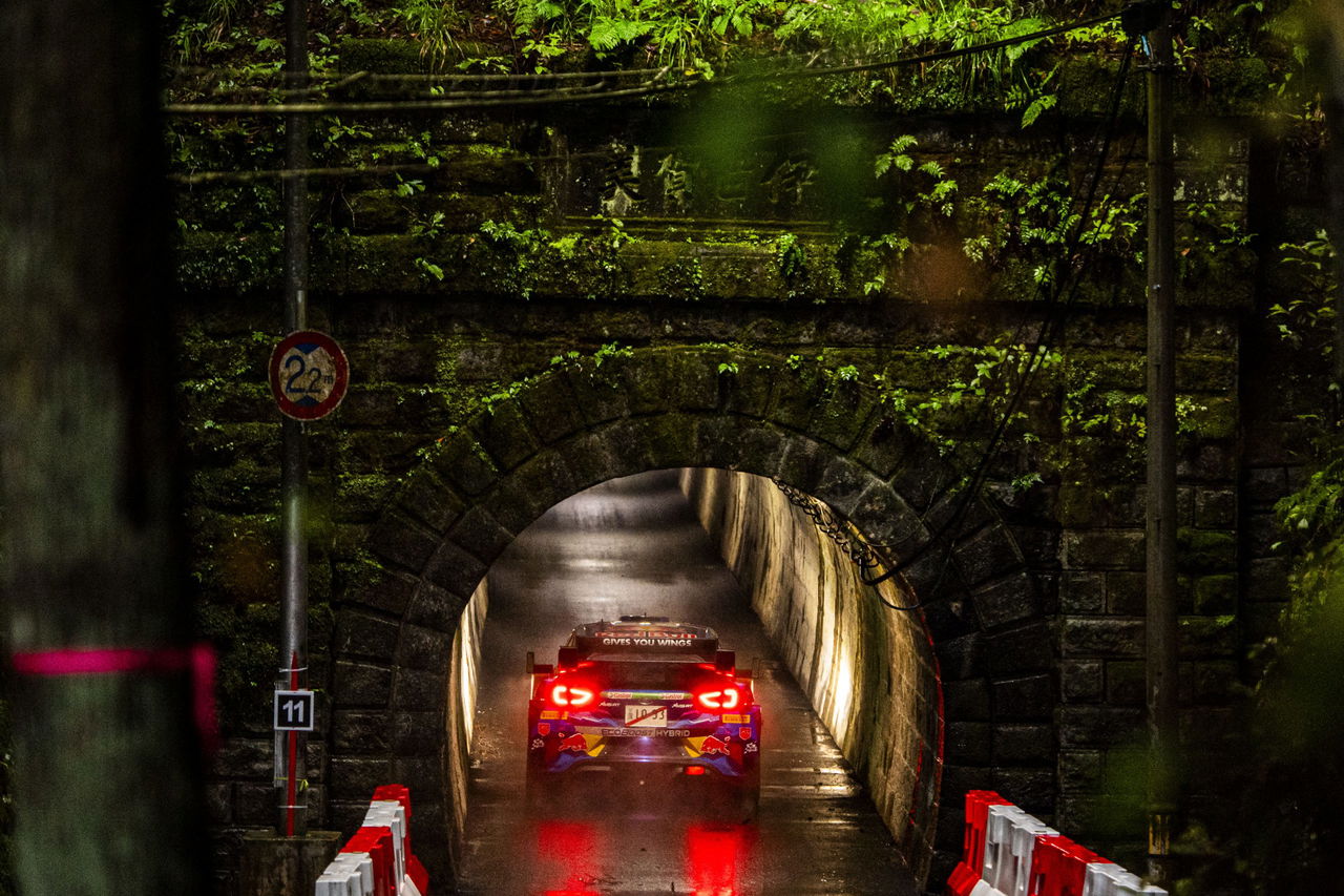 El coche del WRC se adentra en un túnel en Japón, mostrando su diseño único.