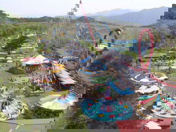 Vista aérea de un parque de atracciones en Sendai, rodeado de montañas.