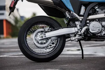 Vista lateral del escape y llanta de la Suzuki DR-Z4SM, ideal para la aventura