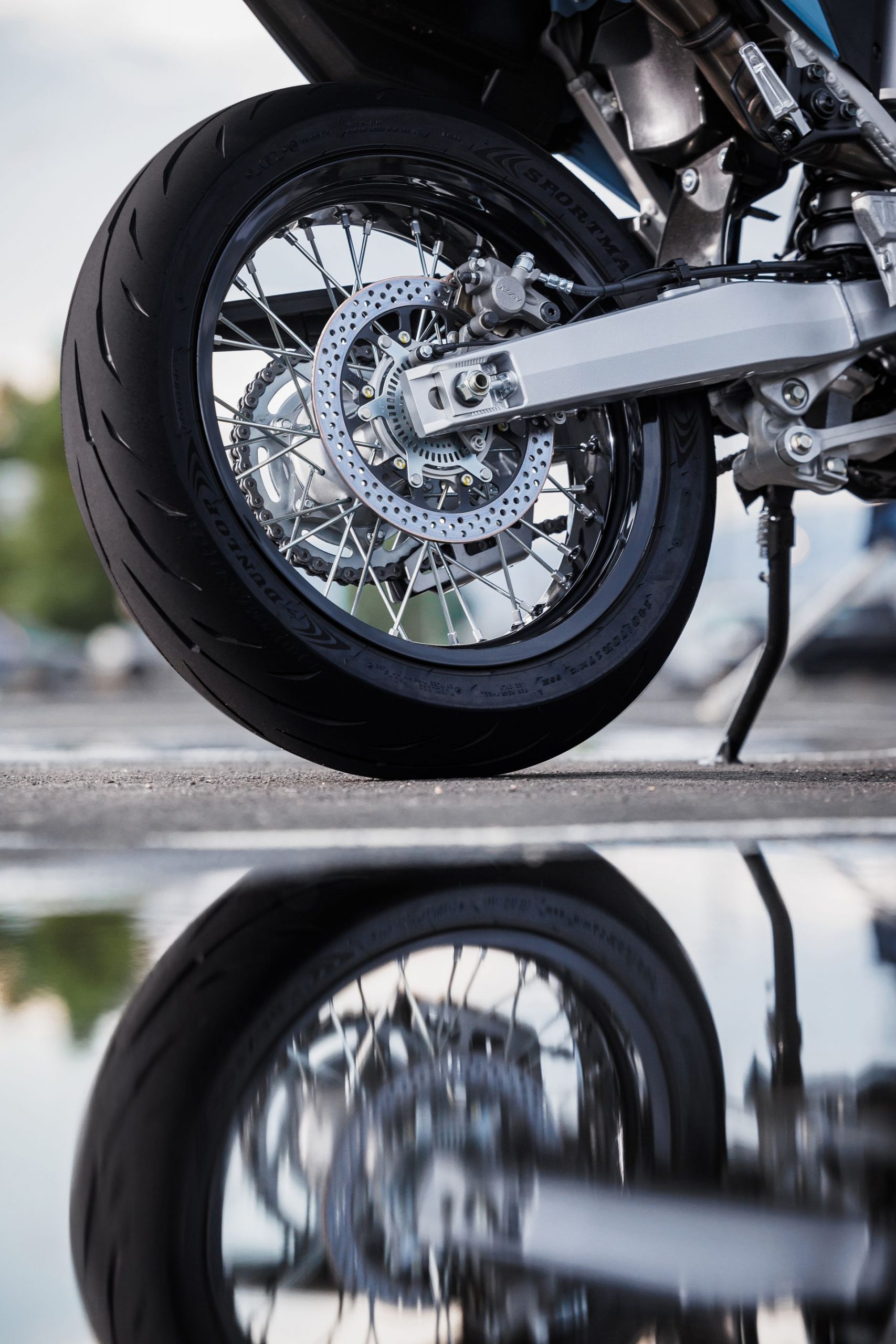 Vista detallada de la rueda trasera del SUZUKI DR-Z4SM, mostrando su diseño robusto.