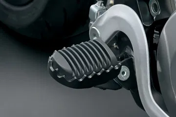 Placa de apoyo del piloto en la Suzuki DR-Z4SM, diseñada para un agarre óptimo.