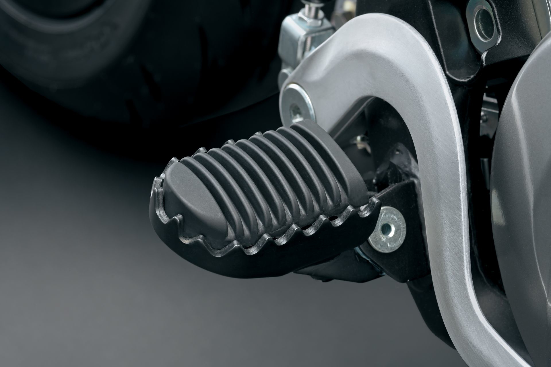 Placa de apoyo del piloto en la Suzuki DR-Z4SM, diseñada para un agarre óptimo.