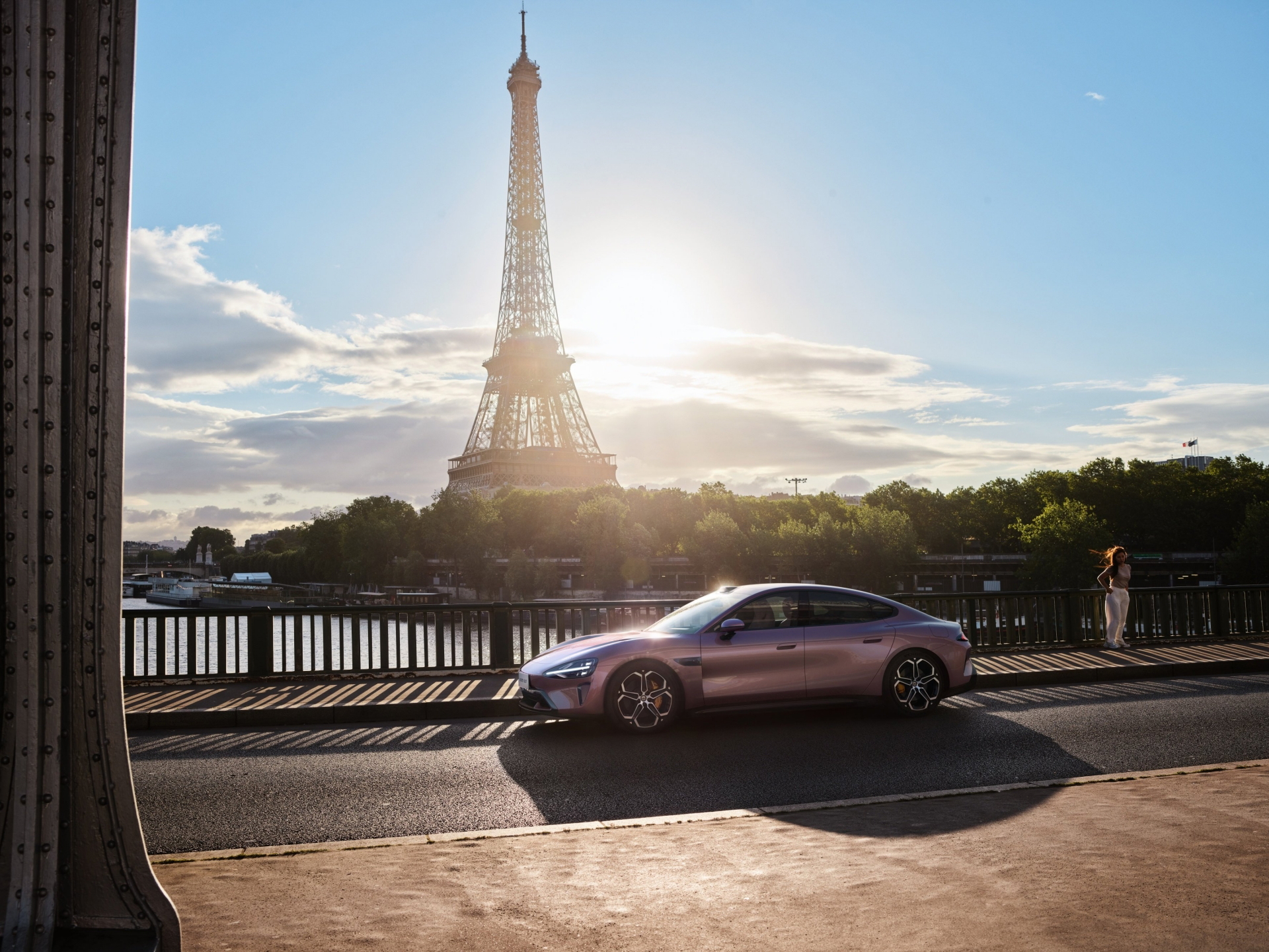 El Xiaomi SU7 se muestra al atardecer junto a la Torre Eiffel, destacando su diseño moderno.