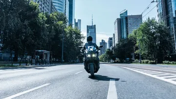 Vista trasera del icónico Yamaha TMAX 2025 en movimiento.