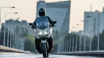 Vista frontal dinámica del Yamaha TMAX 2025, emblema de deportividad y diseño.