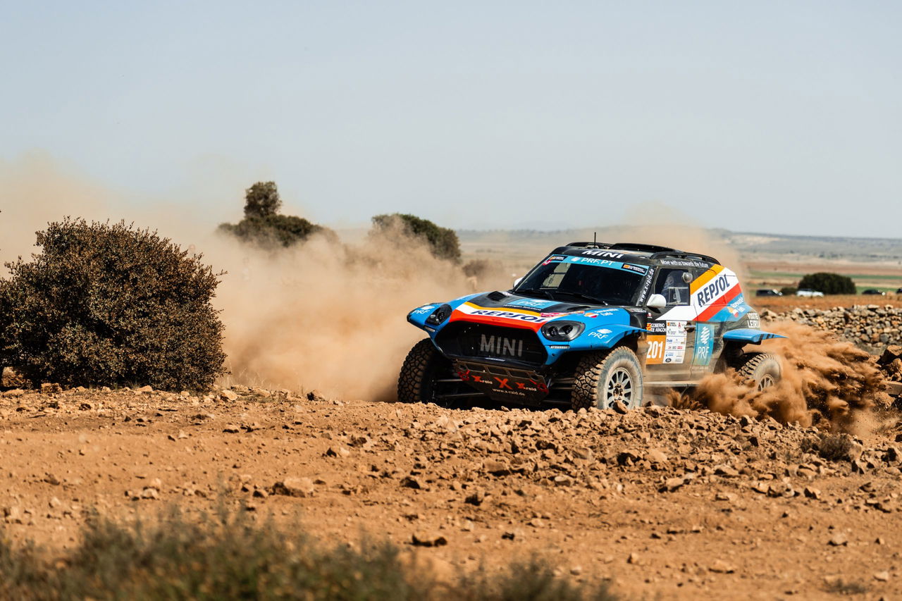 Un Mini compite en una etapa del Rally Dakar, mostrando su potencia y agilidad en terrenos difíciles.
