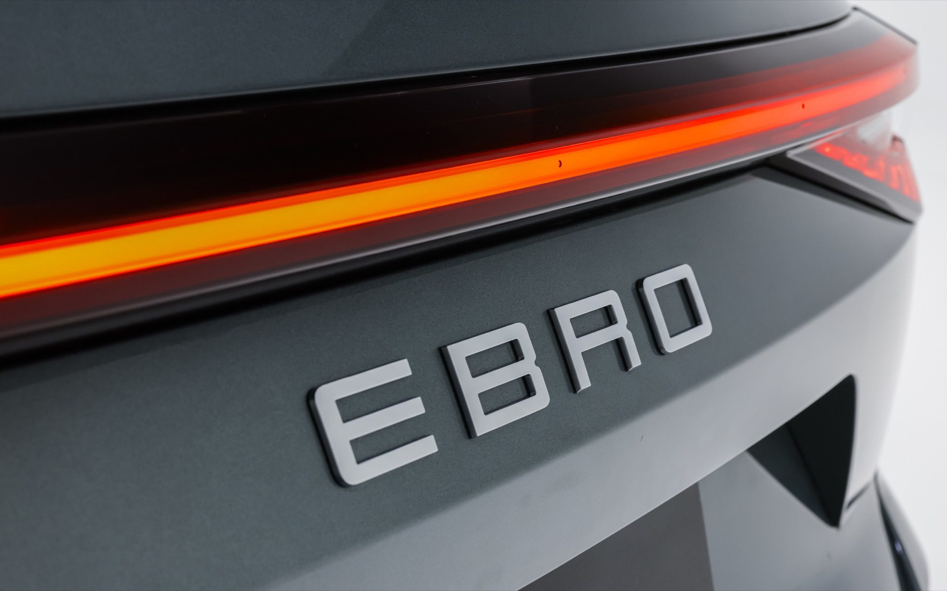 Vista detallada del emblema Ebro en el SUV, destacando su moderna iluminación.