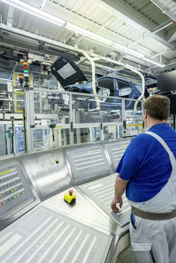 Operario supervisando el proceso de ensamblaje en la fábrica de Volkswagen.