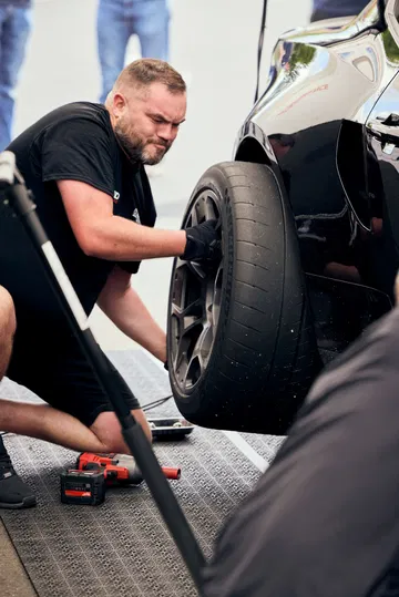 Un técnico trabaja en el neumático del Ford Mustang GTD, afinando su rendimiento para la pista.