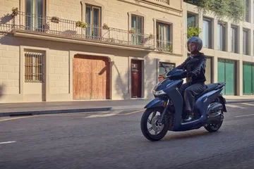 Honda SH350i 2025 en acción urbana, destacando su diseño elegante y moderno.