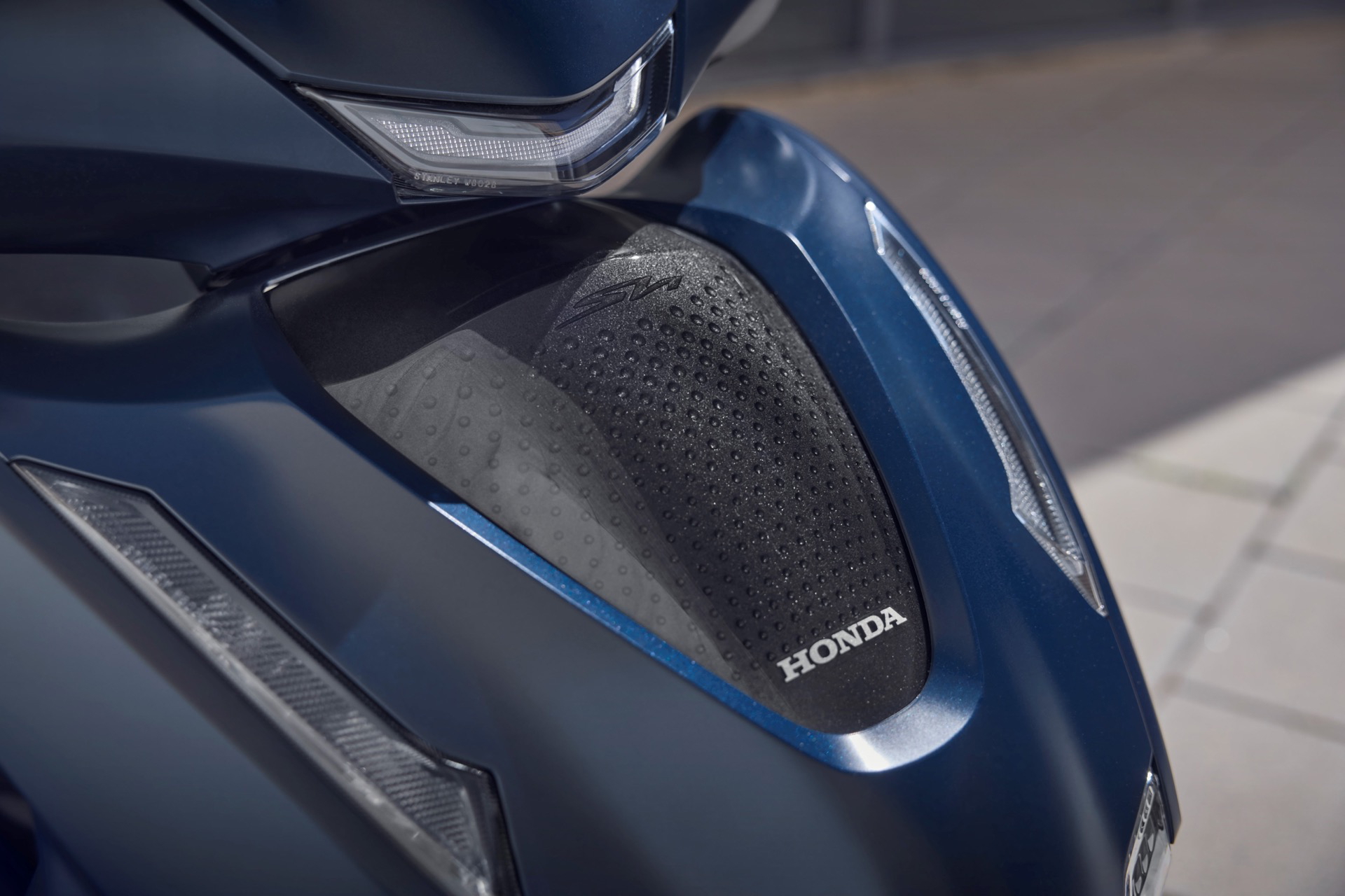 Vista detallada de la parte lateral del scooter, destacando su diseño moderno y funcional.