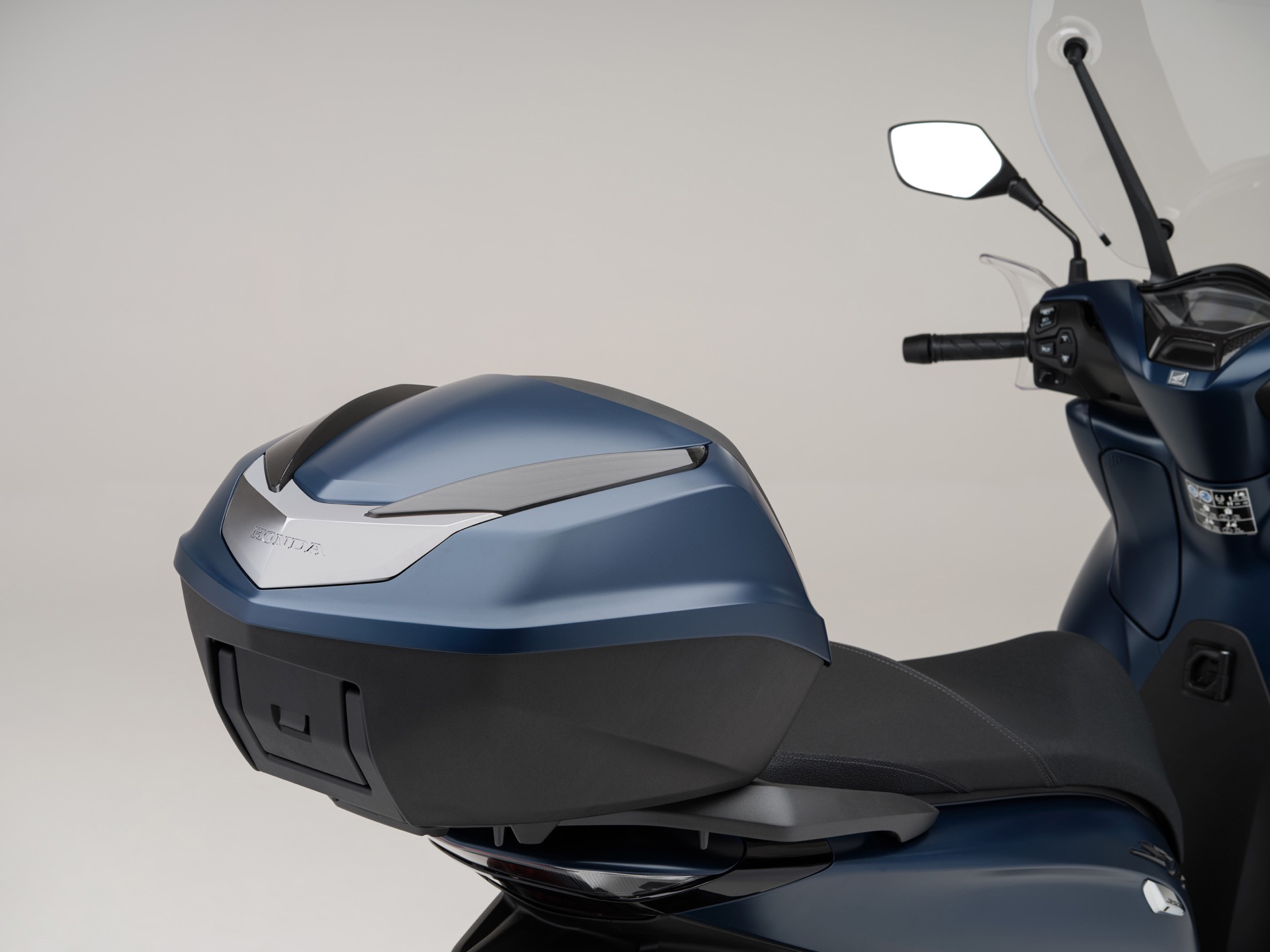 Detalle del lateral de la Honda SH350i, destacando su diseño ergonómico y funcional.