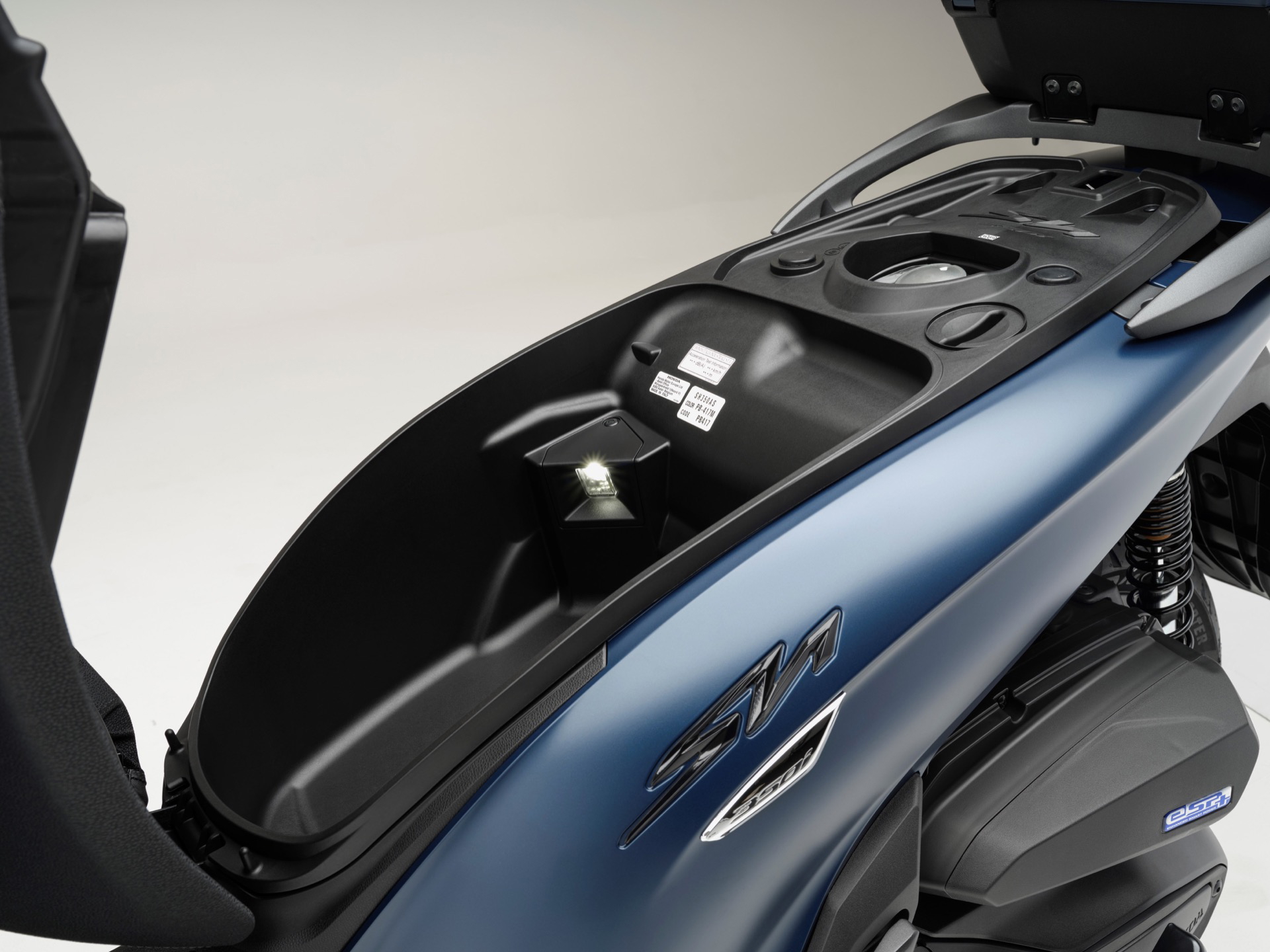 Detalle del compartimento de almacenamiento de la Honda SH350i, práctica y funcional.