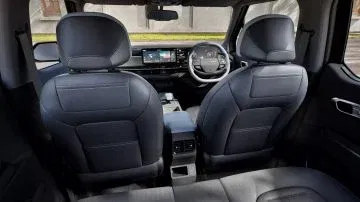 Vista del interior trasero que muestra asientos cómodos y un diseño moderno. Vista del interior trasero que muestra asientos cómodos y un diseño moderno.