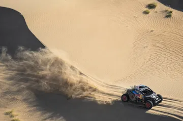 Carlos Sainz y Lucas Cruz en su vehículo en el desierto durante el Rally Dakar 2025.