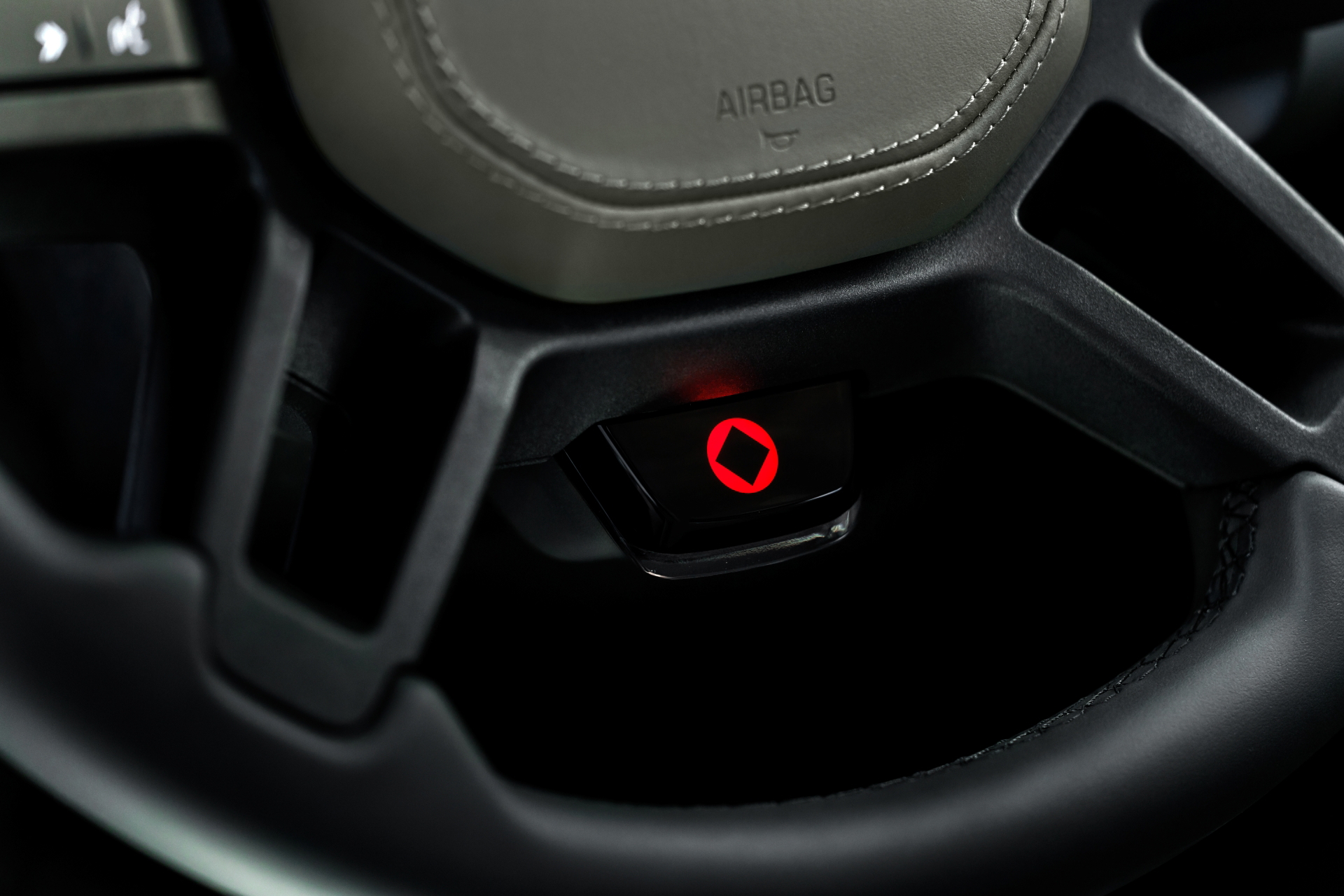 Detalle del volante del Defender Octa, mostrando un interruptor resaltado.