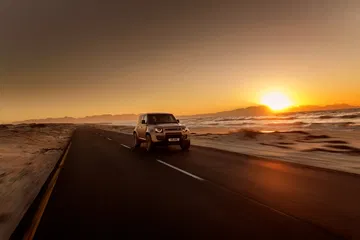 Un Defender Octa arrastra su imponente figura al caer el sol, listo para el todoterreno.