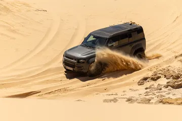 El Defender Octa se desliza con confianza en la arena, mostrando su potencia y versatilidad.