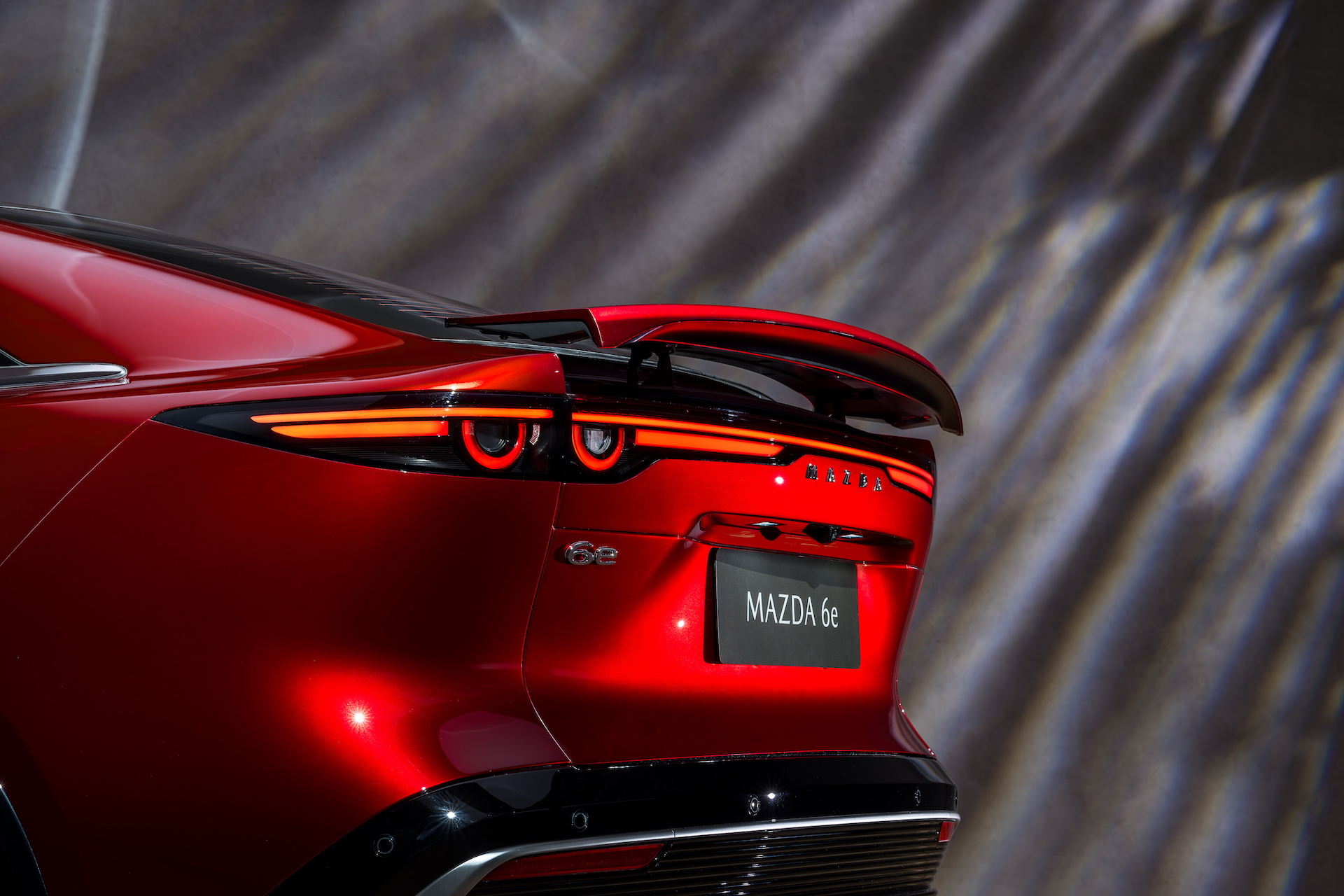 Vista detallada de la trasera del Mazda 6e, resaltando su diseño elegante y aerodinámico.