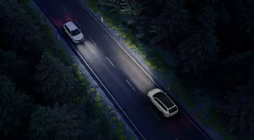 Vista del Skoda Enyaq 2025 iluminando el camino nocturno.