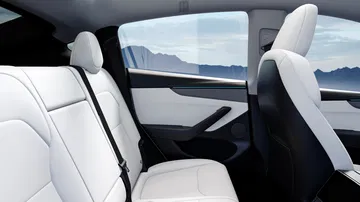 Vista del interior trasero del Tesla Model Y, destaca su diseño minimalista y asientos espaciosos.