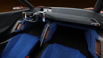 Vista del interior con asientos deportivos en azul y un diseño futurista.